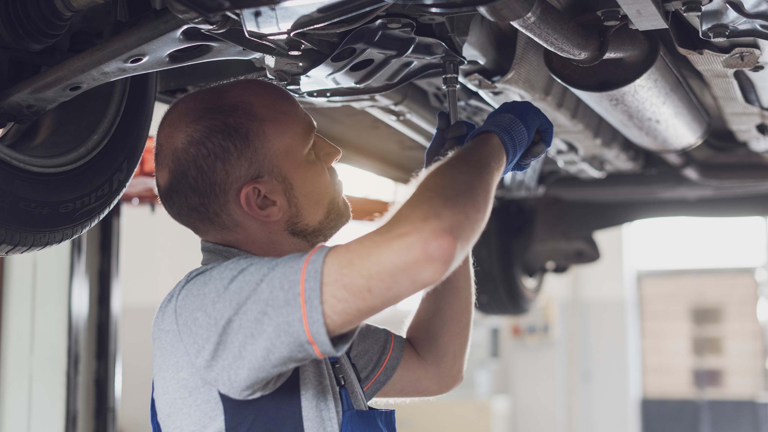 Professional mechanic working under a car